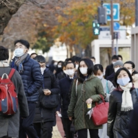 People walk to work in Tokyo\'s Kasumigaseki district, where most government ministries are located, in January. | KYODO
