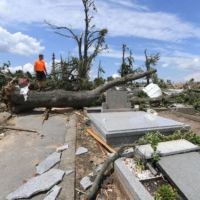 A man surveys debris at a damaged cemetery on June 25 in the village of Mikulcice, Czech Republic, after it was hit by a tornado. | APA / VIA AFP-JIJI