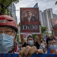 People gather outside the Chinese Embassy in Manila in June to protest against continued Chinese intrusions into Philippine waters.  | GETTY IMAGES / VIA BLOOMBERG 