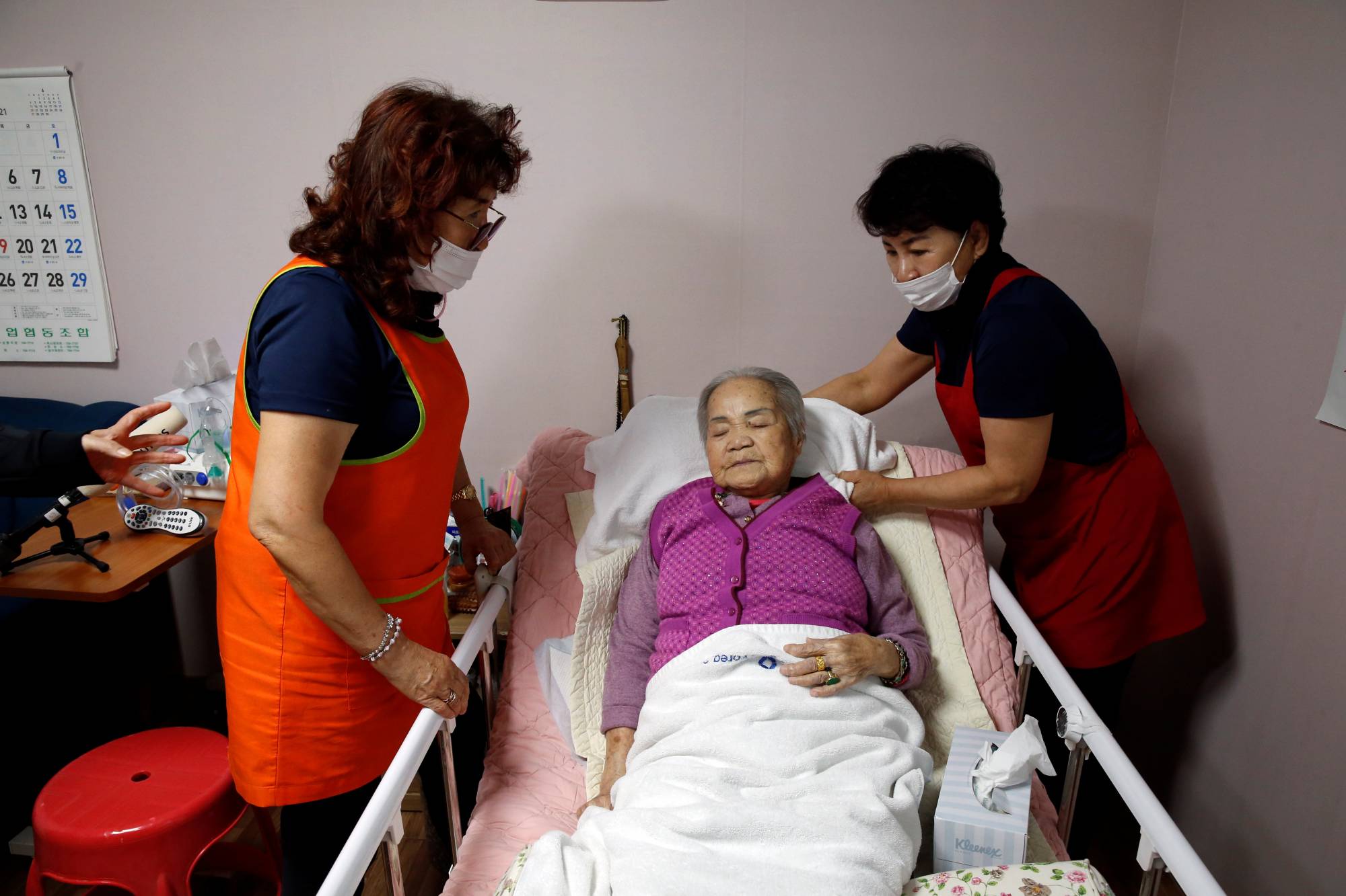 Former South Korean 'comfort woman' Lee Ok-sun lies in bed after an interview at the House of Sharing in Gwangju-si, Gyeonggi-do, South Korea, on May 4. | REUTERS