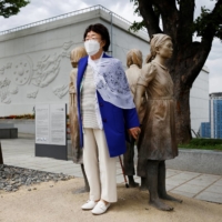 A former South Korean \"comfort woman\" poses for photographs at the Seoul Comfort Women Memorial in Seoul on June 29. | REUTERS