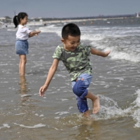 Children play on a beach in Qinhuangdao, in northern China\'s Hebei province, on Sunday.  | AFP-JIJI