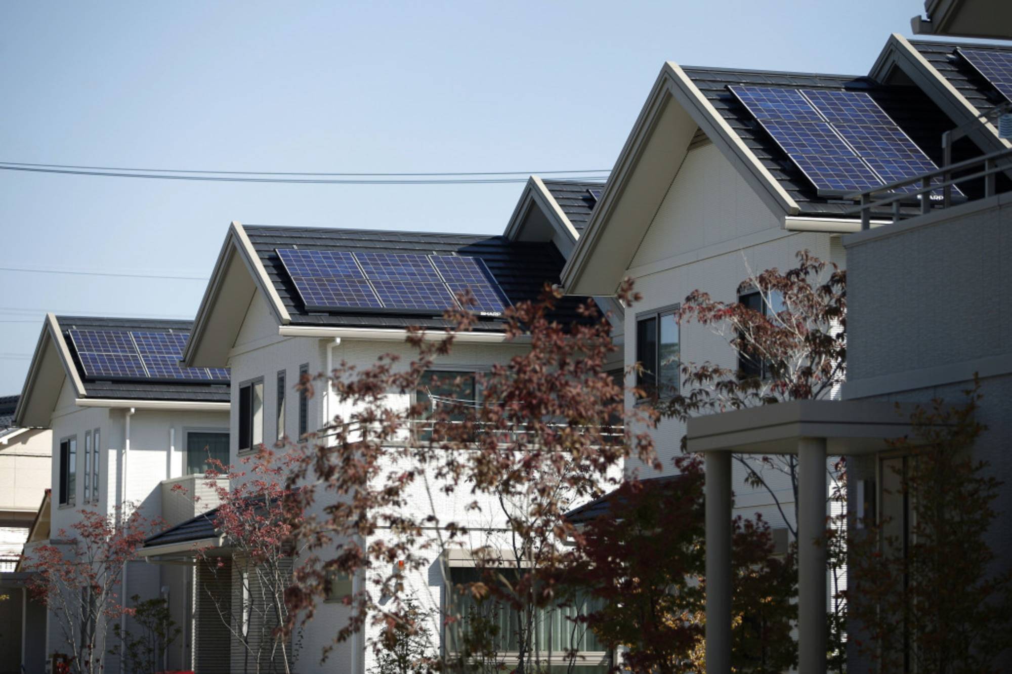 Solar panels sit on the rooftops of smart homes developed by Toyota Motor Corp. in the city of Toyota, Aichi Prefecture. Japan is studying how to lower its dependence on dirty fossil fuels as it grapples with limited available space and a large anti-nuclear contingent. | BLOOMBERG