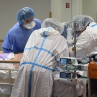 Medical workers treat a severely ill COVID-19 patient at Kindai University Hospital in Sayama, Osaka Prefecture, in August. | KINDAI UNIVERSITY HOSPITAL / VIA KYODO
