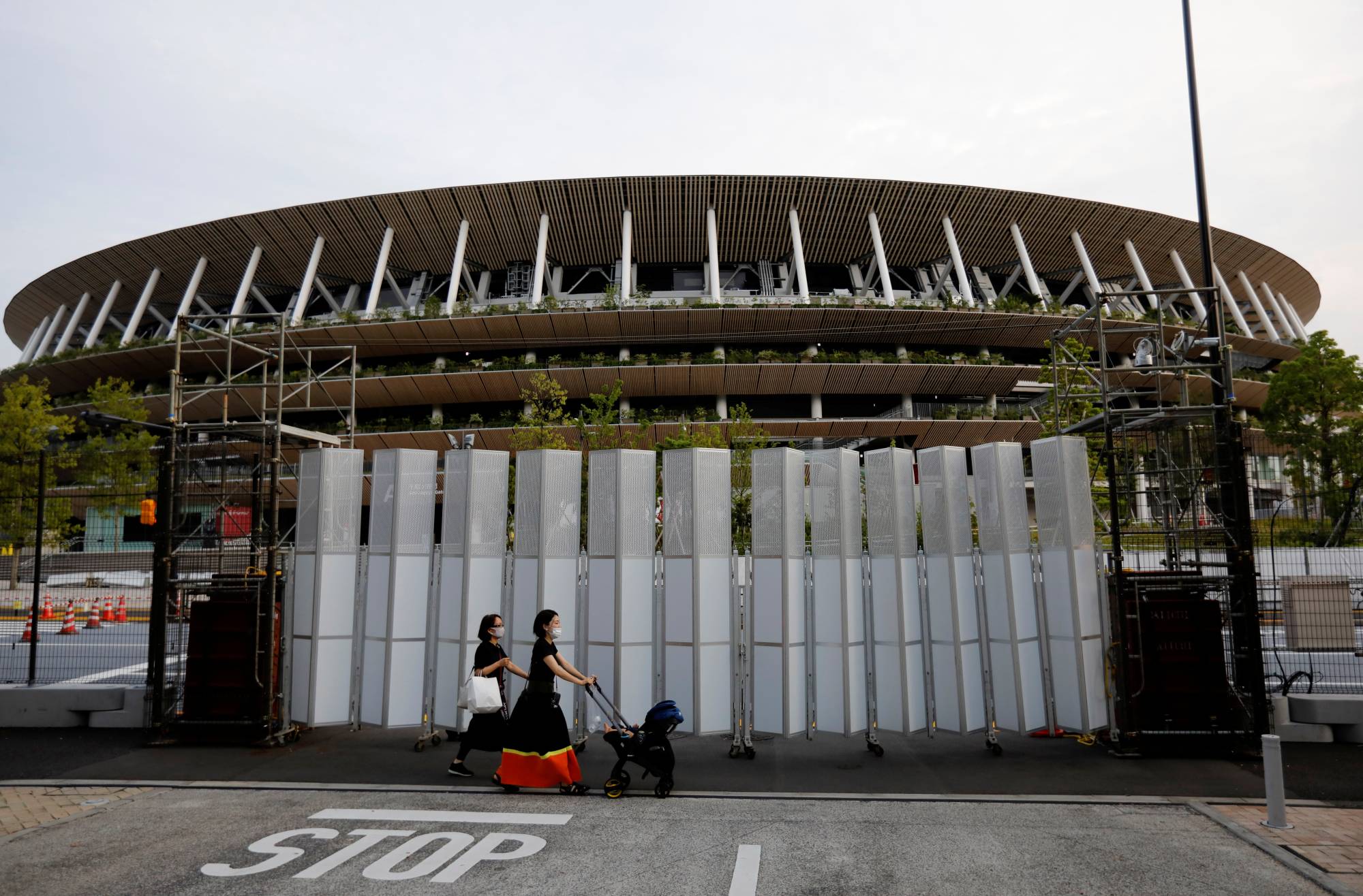 Pedestrians walk in front of the National Stadium in Tokyo on Wednesday. | REUTERS