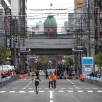 Runners compete in an Olympic test event in Sapporo in May. The public will be asked not to line the route of the Olympic marathon over fears that crowds of fans could spread coronavirus infections.  | AFP-JIJI