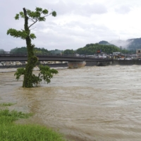 Water levels surge in the Sendai River in the town of Satsuma, Kagoshima Prefecture, on Saturday morning. | KYODO