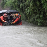 Rescue workers evacuate residents from a flooded area amid heavy rainfall in Hefei, Anhui province, China, on Thursday.    | CHINA DAILY / VIA REUTERS  