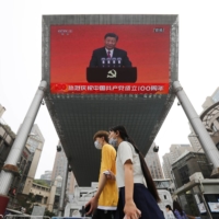 A speech by Chinese President Xi Jinping in shown on a big screen in Beijing on July 1. | REUTERS 