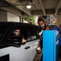 Arnel Smith, a parking attendant in Hoboken, New Jersey, helps a customer at a FlashParking ticket machine. | ANDY ZALKIN / THE NEW YORK TIMES
