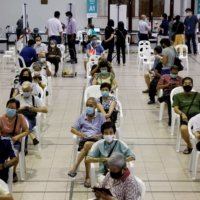 People over 70 years old wait in an observation area after getting a dose of the COVID-19 vaccine at a vaccination center in Singapore on Jan. 27. | REUTERS