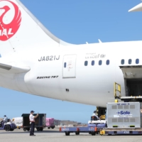 Workers unload AstraZeneca vaccines, shipped from Japan, from an airplane at Taoyuan International Airport in Taiwan on July 8. | TAIWAN CENTERS FOR DISEASE CONTROL / VIA REUTERS