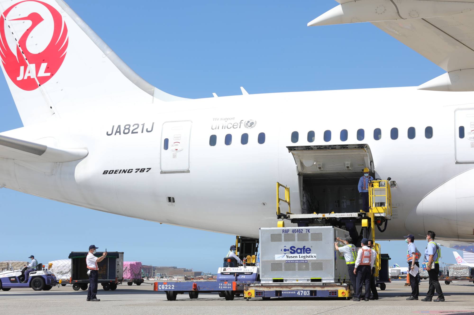 Workers unload AstraZeneca vaccines, shipped from Japan, from an airplane at Taoyuan International Airport in Taiwan on July 8. | TAIWAN CENTERS FOR DISEASE CONTROL / VIA REUTERS