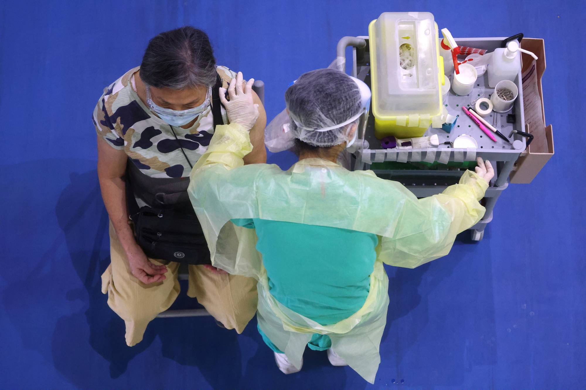 A medical worker administers a dose of the AstraZeneca COVID-19 vaccine to a woman during a vaccination session for people over 75 years old, at a stadium in New Taipei City, Taiwan, on June 25. | Reuters