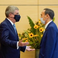 International Olympic Committee President Thomas Bach (left) meets Prime Minister Yoshihide Suga at the Prime Minister\'s Office on Wednesday. | POOL / VIA REUTERS