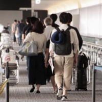 Shimizu Corp. workers and their family members arrive at Narita Airport on Thursday from Indonesia amid a surge of highly contagious delta coronavirus variant cases in the Southeast Asian country. | KYODO