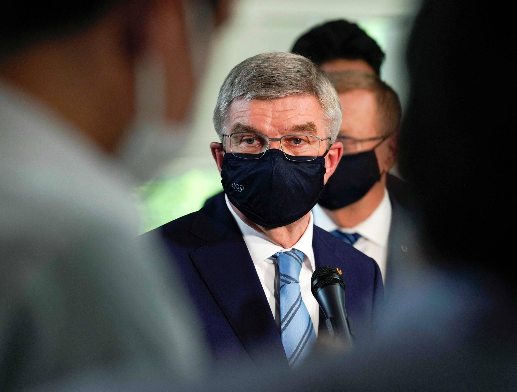 International Olympic Committee President Thomas Bach speaks to the media after meeting Prime Minister Yoshihide Suga in Tokyo on Wednesday. | POOL / VIA AFP