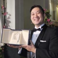 Film director Ryusuke Hamaguchi poses for a photo after winning the Best Screenplay at the annual Cannes International Film Festival in France on Saturday. | KYODO