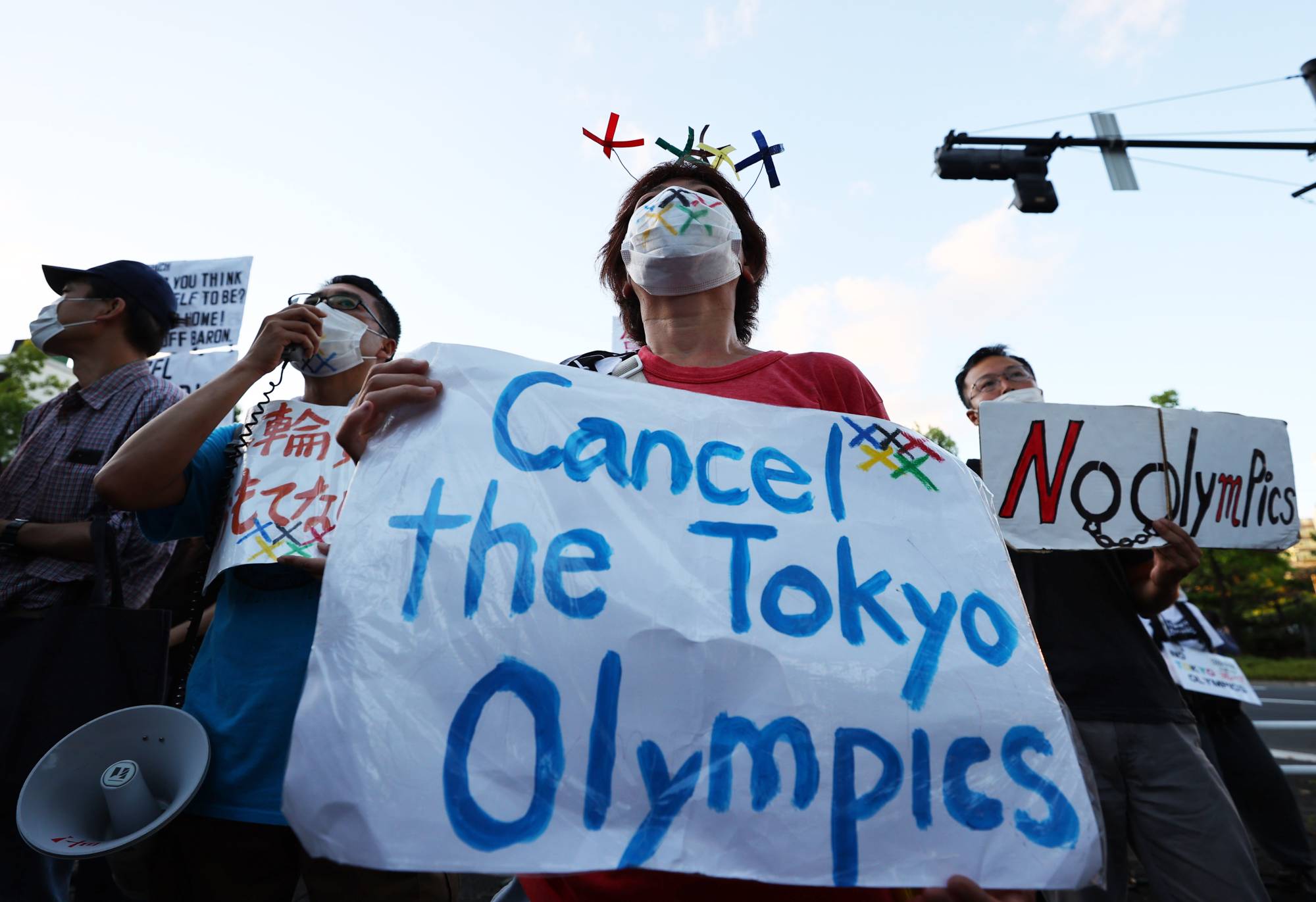 People protest against the Tokyo Olympic Games outside the Akasaka State Guest House, where International Olympic Committee President Thomas Bach attended a welcome ceremony on Sunday. | REUTERS