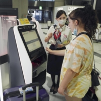 A passenger uses a facial recognition system at Narita Airpot on Monday. | KYODO