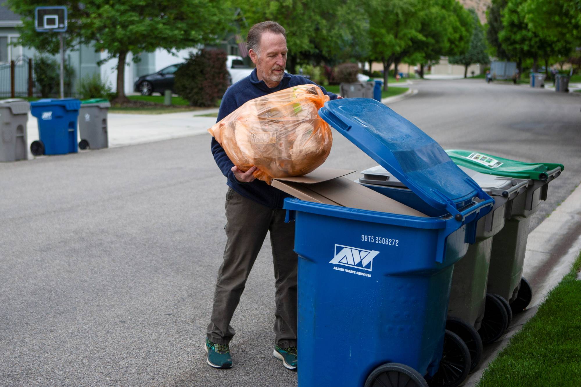 David Garman places his orange Hefty EnergyBag into his recycling bin in Boise, Idaho, on May 21. | REUTERS