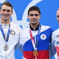 Silver medalist Ryan Murphy (left) of the U.S. poses with gold medalist Evgeny Rylov (center) of the Russian Olympic Committee and bronze winner Luke Greenbank of Britain after the final of the men\'s 200 meter backstroke swimming event at the Tokyo Olympics on Friday. | AFP-JIJI