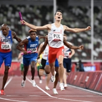 Poland\'s Kajetan Duszynski celebrates as he crosses the finish line in the mixed 4x400m relay final, cinching the gold medal for his team. | AFP-JIJI