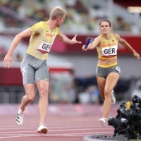 Nadine Gonska of Germany passes the baton to compatriot Manuel Sanders during the final of the 4x400 mixed relay at Tokyo\'s National Stadium on Saturday. | REUTERS