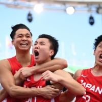 Tomoya Ochiai, Keisei Tominaga and Ryuto Yasuoka celebrate after beating China in a preliminary match on Tuesday.  | AFP-JIJI