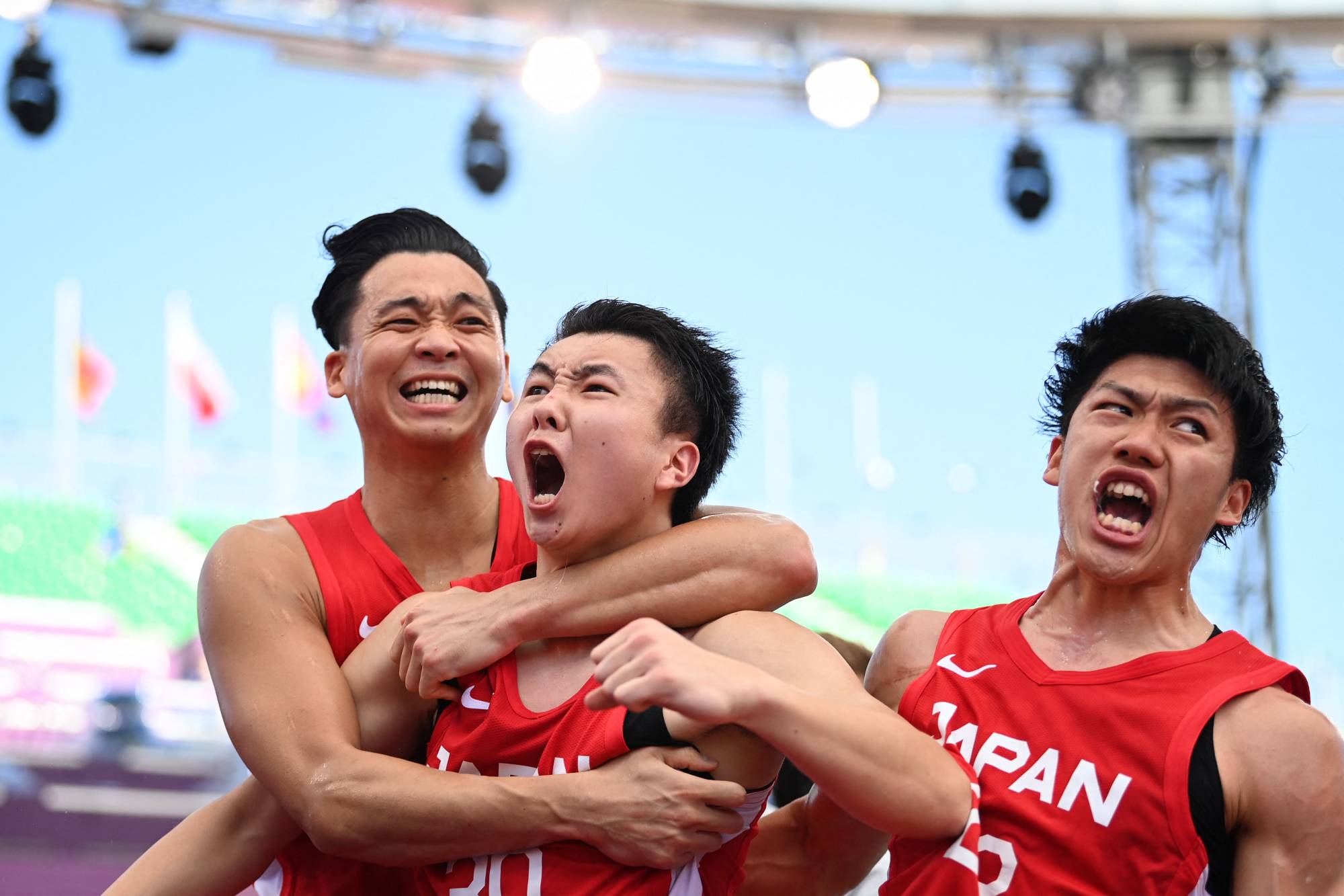 Tomoya Ochiai, Keisei Tominaga and Ryuto Yasuoka celebrate after beating China in a preliminary match on Tuesday. | AFP-JIJI