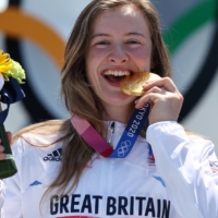 Gold medalist Charlotte Worthington of Britain takes a bite of her gold medal from the women\'s BMX freestyle event.  | REUTERS