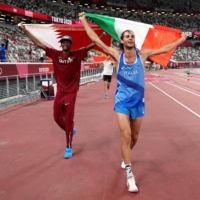Gold medalists Mutaz Essa Barshim (left) of Qatar and Gianmarco Tamberi of Italy celebrate on the track following the men\'s high jump final during the Tokyo Olympics at the National Stadium in the capital on Sunday. | POOL / VIA AFP-JIJI