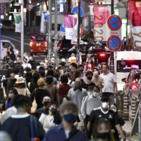 People walk in Tokyo\'s Shibuya district on Saturday as COVID-19 infections continue to surge. | KYODO