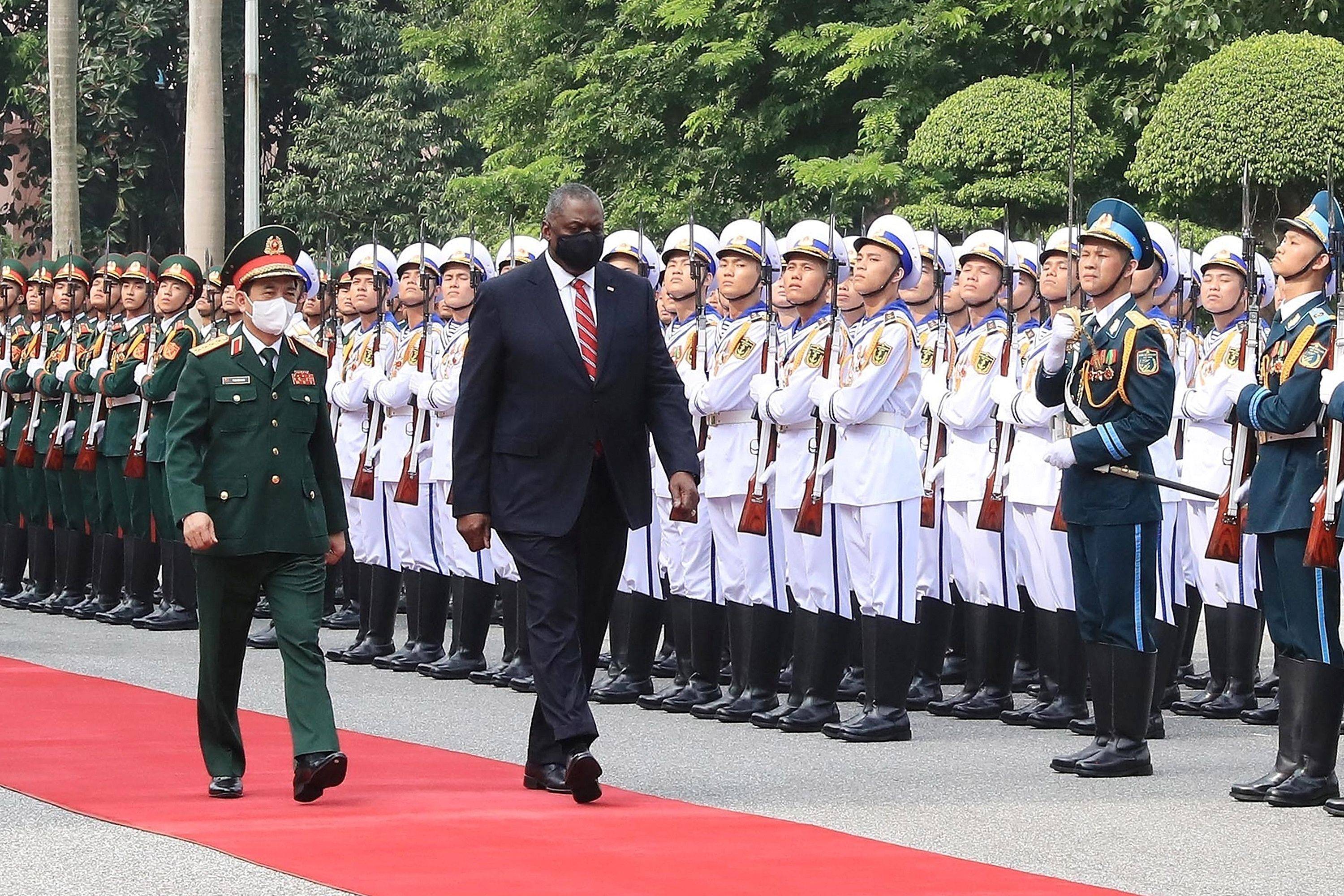 U.S. Secretary of Defense Lloyd Austin (center) inspects a guard of honor  along with Vietnamese Defense Minister Phan Van Giang during a welcoming ceremony in Hanoi on Thursday. | STR / VIETNAM NEWS AGENCY / VIA AFP-JIJI