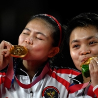 Indonesia\'s Apriyani Rahayu (right) and Greysia Polii pose with their women\'s doubles badminton gold medals at a ceremony during the Tokyo Olympics at the Musashino Forest Sports Plaza in the capital on Monday. | AFP-JIJI