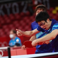 Japan\'s Jun Mizutani (front) and Koki Niwa take part in a match against Australia\'s Heming Hu and Xin Yan during the men\'s team table tennis competition at the Metropolitan Gymnasium in Tokyo on Monday. | REUTERS