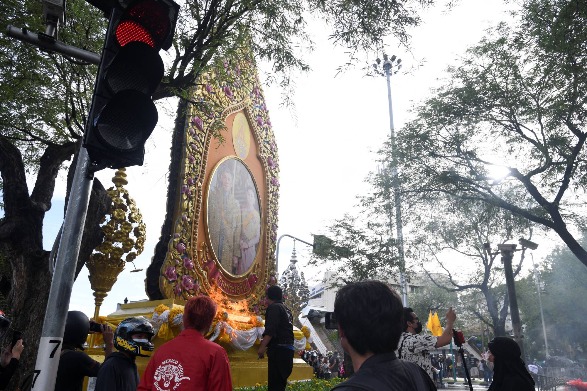 Protesters attempt to burn a portrait of Thailand's King Maha Vajiralongkorn and Queen Suthida during a march in Bangkok on July 18. | REUTERS 