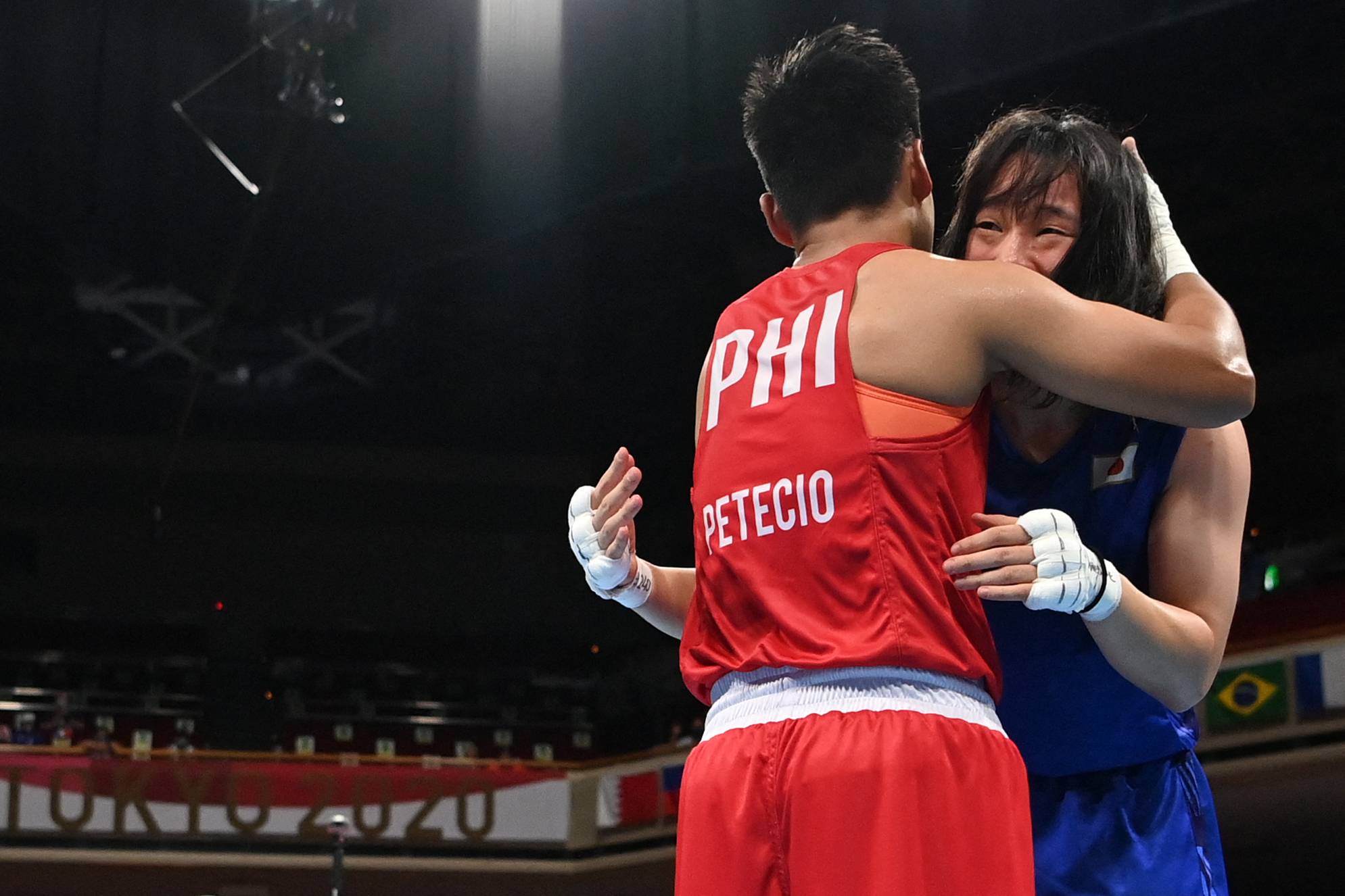 Japan's Sena Irie and the Philippines' Nesthy Petecio embrace after their gold medal bout.  | AFP-JIJI