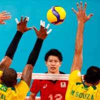 Yuji Nishida of Japan hits the ball as Brazil\'s Leal and Mauricio Souza go up for a block during their men\'s quarterfinal match on Tuesday.  | REUTERS