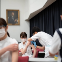A nurse receives their first dose of the Pfizer COVID-19 vaccine in March at Komagome Hospital. There are over 700,000 licensed but unemployed nurses in Japan who are qualified to administer vaccines. | RYUSEI TAKAHASHI

