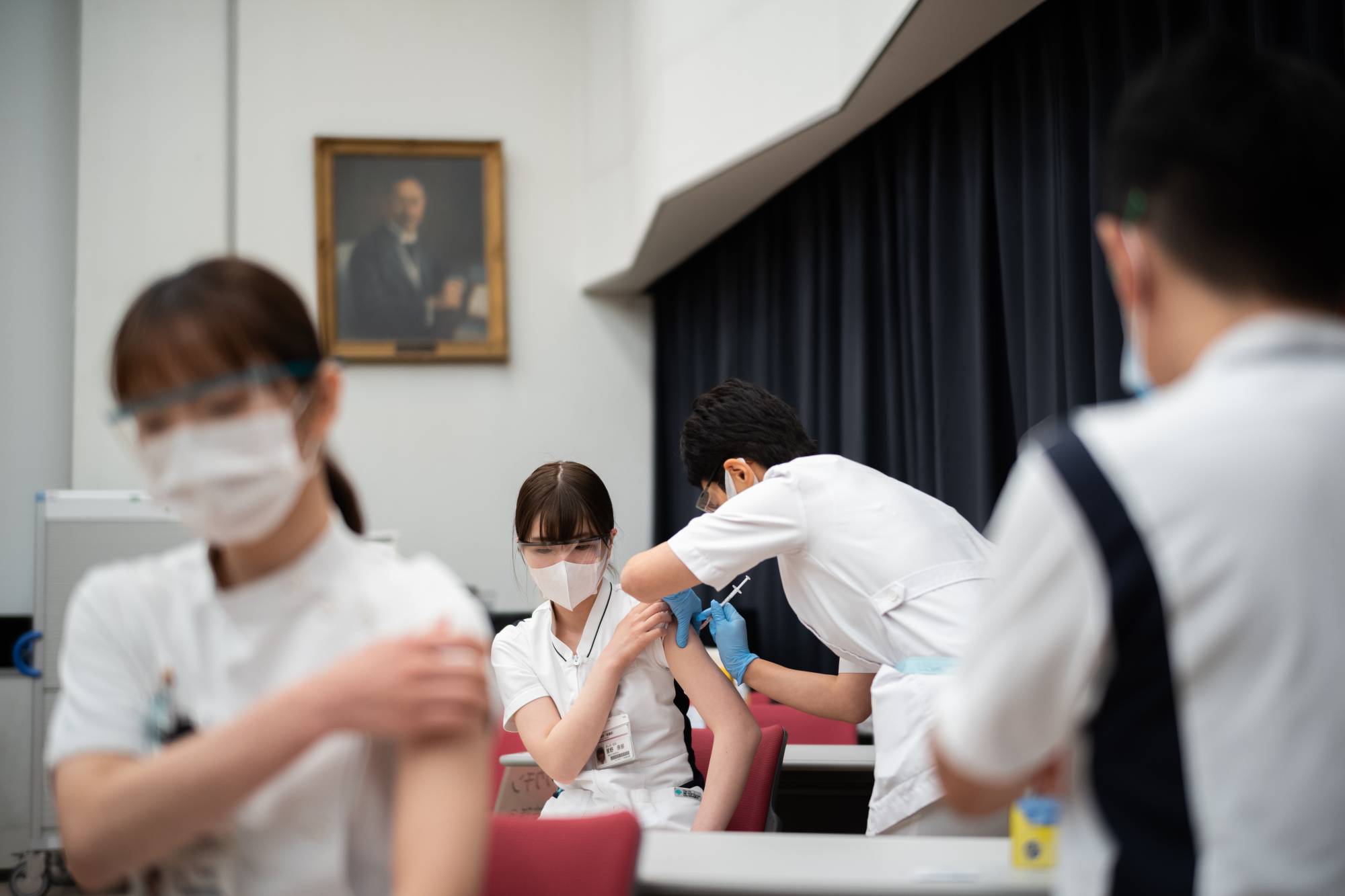 A nurse receives their first dose of the Pfizer COVID-19 vaccine in March at Komagome Hospital. There are over 700,000 licensed but unemployed nurses in Japan who are qualified to administer vaccines. | Ryusei Takahashi 