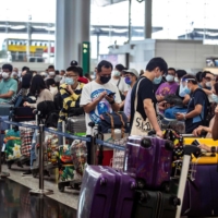 People check in for a flight to the U.K. at Hong Kong International Airport in July.  | AFP-JIJI