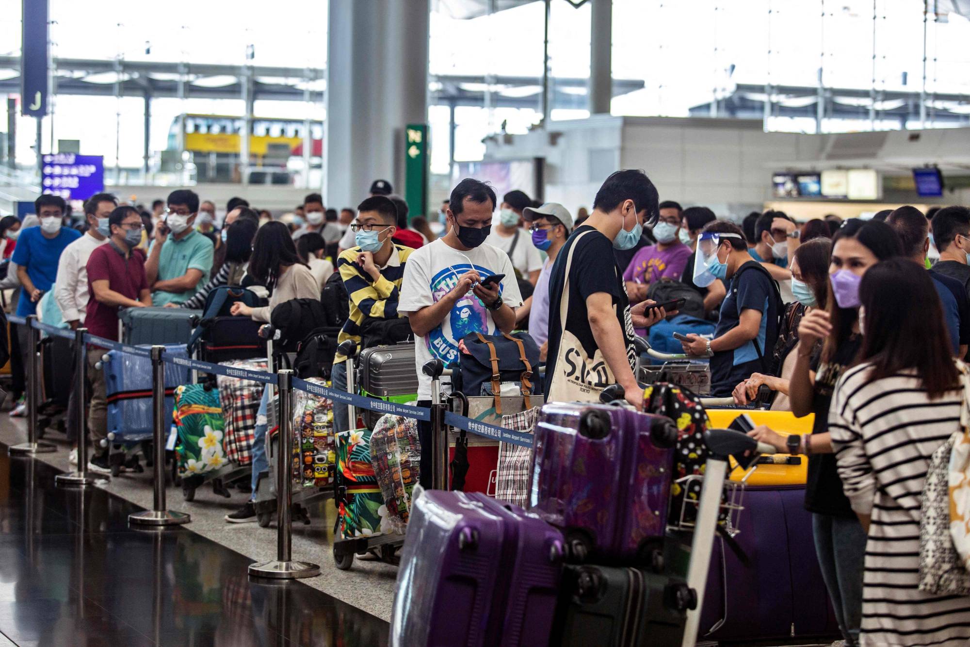 People check in for a flight to the U.K. at Hong Kong International Airport in July. | AFP-Jiji