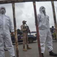 Policemen stand at a security check point on a street in Karachi on Monday after a partial lockdown was imposed to curb the spread of the coronavirus. | AFP-JIJI