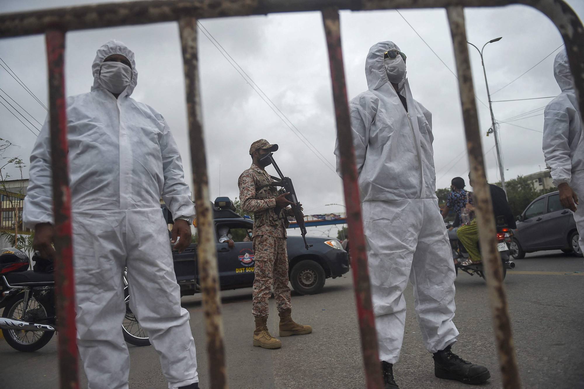 Policemen stand at a security check point on a street in Karachi on Monday after a partial lockdown was imposed to curb the spread of the coronavirus. | AFP-JIJI