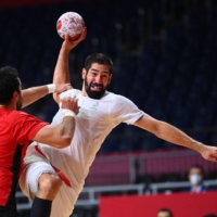 France\'s Nikola Karabatic (right) is challenged as he shoots during the men\'s semifinal handball match between France and Egypt. | AFP-JIJI