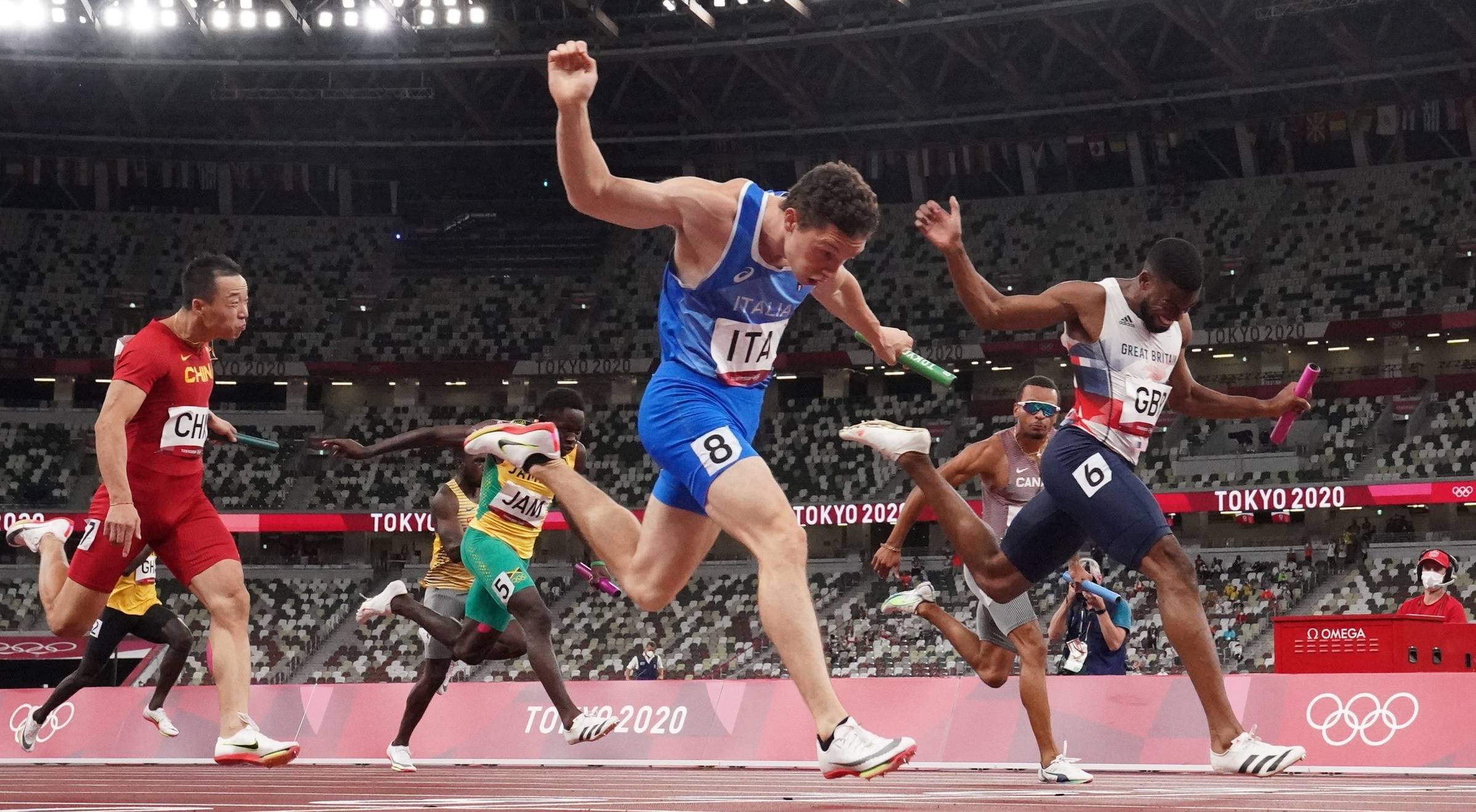 Italy's Filippo Tortu (wearing No. 8) crosses the finish line first to secure the gold medal for his nation in the men's 4x100-meter final at National Stadium on Friday.  | REUTERS