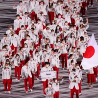 Members of Japan\'s Olympic delegation walk into the National Stadium during the opening ceremony of the Tokyo Games on July 23. | REUTERS