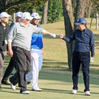 U.S. President Donald Trump fist-bumps Prime Minister Shinzo Abe as Japanese professional golfer Hideki Matsuyama looks on during a round of golf at Kasumigaseki Country Club in Kawagoe, Saitama Prefecture, in November 2017. The 92-year-old club has long been a province of the elite. | CABINET PUBLIC RELATIONS OFFICE / VIA REUTERS