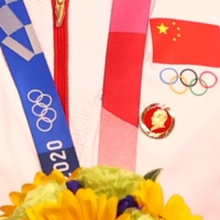 A badge of the late Chinese leader Mao Zedong is seen pinned to the tracksuit of a Chinese cyclist during a medal ceremony at the Izu Velodrome in Shizuoka Prefecture on Monday. | REUTERS